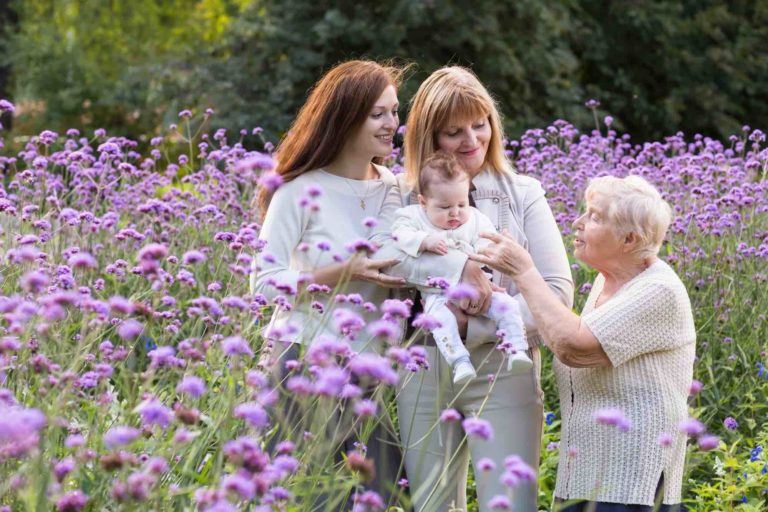 3 Generationen Grossmutter, Tochter und Kind stehen in der Blumenwiese