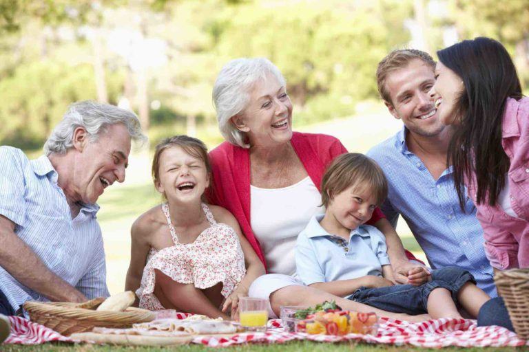 Drei Generationen Familie sitzt im Gras